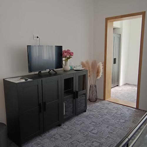 a living room with a television on a black cabinet at Check-In Kaya in Sibiu