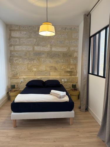 une chambre avec un lit et un mur de briques dans l'établissement O cosy, à Avignon