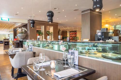 a restaurant with two tables and a bar at Fletcher Hotel-Restaurant Nieuwegein-Utrecht in Nieuwegein