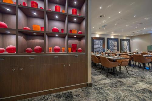 a dining room with tables and red bowls on the wall at Fletcher Hotel-Restaurant Nieuwegein-Utrecht in Nieuwegein
