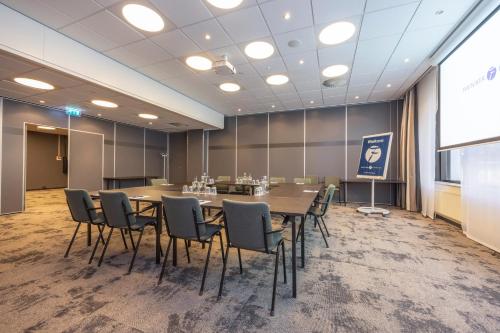 a conference room with a long table and chairs at Fletcher Hotel-Restaurant Nieuwegein-Utrecht in Nieuwegein