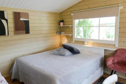 a small bedroom with a bed and a window at Stiilne majake saunaga in Kuusiku