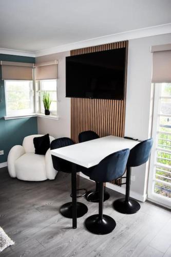 a living room with a table and a couch at Bathgate Penthouse near Edinburgh in Bathgate