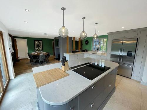 a large kitchen with a island in the middle at Mallards - English Countryside Retreat in Lindsell