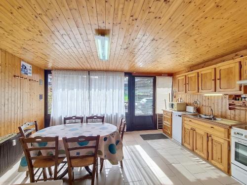 une cuisine avec une table et des chaises dans une pièce dans l'établissement Mont Caly Pluv - appartement - 6pers, aux Gets