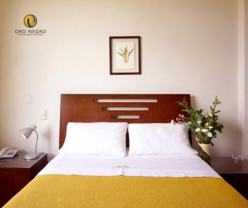 a bedroom with a bed with a yellow and white blanket at Hotel Oro Negro in Talara