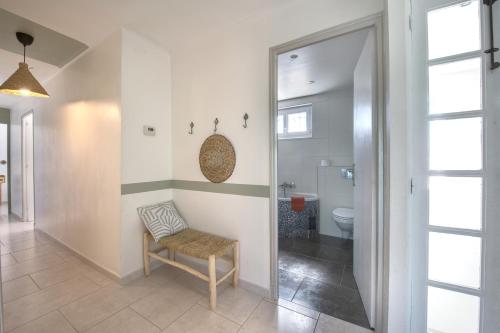 La salle de bains est pourvue d'une chaise et de toilettes. dans l'établissement L'Oustal Occitan, à Saint-Privat-des-Vieux