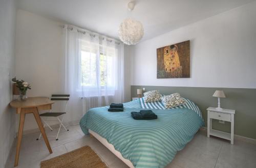 une chambre avec un lit et un bureau dans l'établissement L'Oustal Occitan, à Saint-Privat-des-Vieux