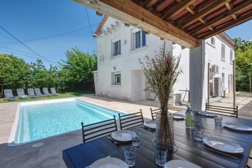 - une table avec des chaises à côté de la piscine dans l'établissement L'Oustal Occitan, à Saint-Privat-des-Vieux