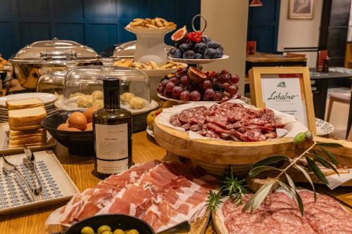 a table with a bunch of food and a bottle of wine at Hotel Laguna - Terme Krka in Strunjan