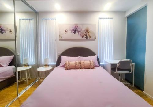 a bedroom with a large bed and a mirror at Luxury Apartment Minutes from City w Rooftop Pool & Parking in Canberra