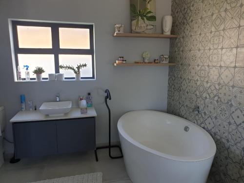 a bathroom with a white tub and a sink at Sassa in St Helena Bay