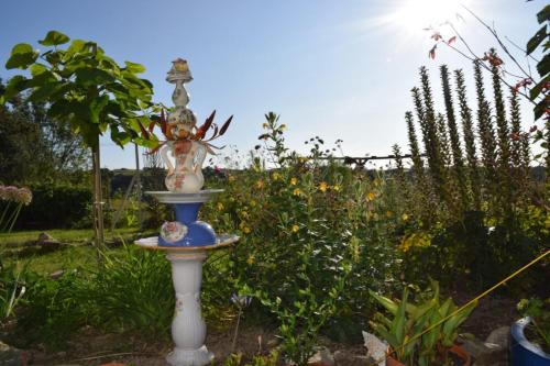 a bird bath in the middle of a garden at B&B La Fleur in Saint-Fargeol