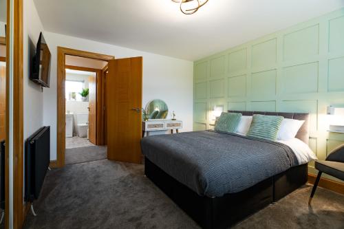 a bedroom with a bed and a bathroom at 24 Kingsford Court in Newton Mearns