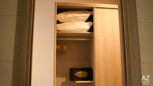a cabinet with pillows and towels in a room at AZ hôtel des arts in Rabat