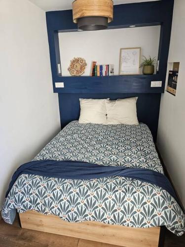 Ce lit se trouve dans un dortoir doté d'une tête de lit bleue. dans l'établissement Petit Appart proche IMA, à Niort