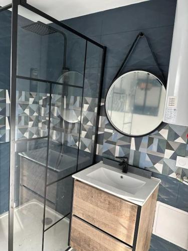 une salle de bain avec un lavabo et un miroir dans l'établissement Petit Appart proche IMA, à Niort