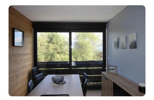 une salle à manger avec une table et une grande fenêtre dans l'établissement las soucarrades, à Égat