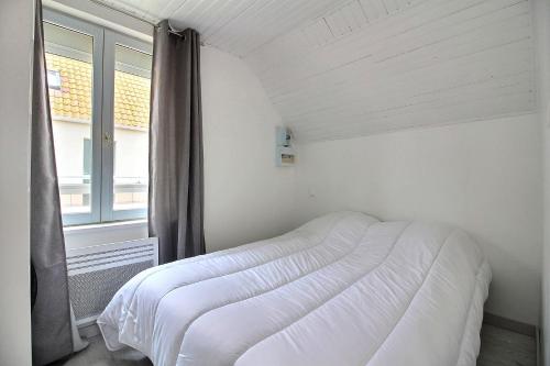 un lit blanc dans une chambre avec une fenêtre dans l'établissement Appt Cosy 4 personnes A 2 min a pied plage et commerces, à Berck-sur-Mer