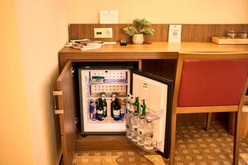 a small refrigerator in a room with a desk at Petrodava ONE in Piatra Neamţ