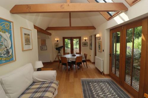 a living room with a couch and a table at Idyllic 15th century farmhouse with hot tub in Petham