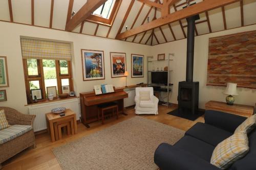 a living room with a couch and a desk at Idyllic 15th century farmhouse with hot tub in Petham