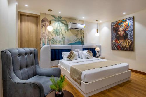 a bedroom with a king sized bed and a chair at The Orion Elite - Green Park in New Delhi