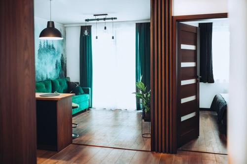 a living room with a green couch and a wooden door at Apartament Panorama in Mława