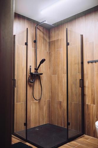 a shower in a bathroom with wooden walls at Apartament Panorama in Mława