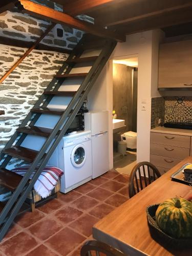 a laundry room with a washing machine and a staircase at Sweet Stone Cottage in Tsagarada