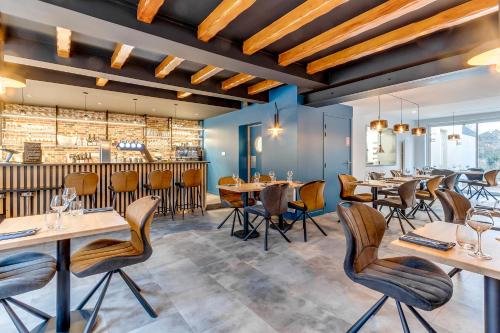 a restaurant with tables and chairs and a bar at Le Bonhomique in Seclin