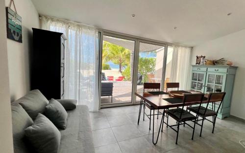 a living room with a couch and a table with chairs at Superbe T2 Sole e Mare NBBC sur la plage de Baie Nettlé in Baie Nettle