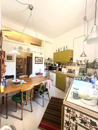 - une grande cuisine avec une table en bois dans l'établissement Charme des Lices, à Arles