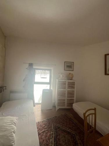 Cette chambre blanche dispose de deux lits et d'une fenêtre. dans l'établissement Charme des Lices, à Arles