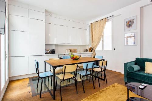 une cuisine et une salle à manger avec une table et des chaises dans l'établissement Authentic apartment - 4BR-10P - Moulin Rouge, à Paris