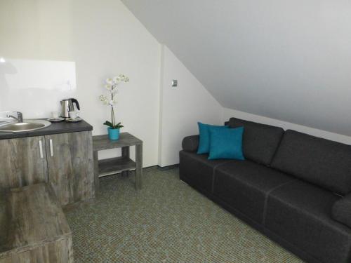 a living room with a couch and a sink at Hotel Giżycko in Giżycko