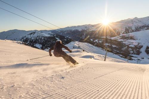 a person riding a snowboard down a snow covered slope at Haus Hanser in Zellberg