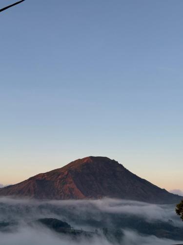 a mountain in the fog with a hill in the background at Pinggan sky in Gretek