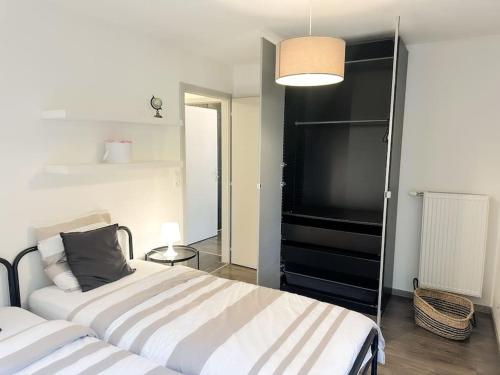 a bedroom with two beds and a black shelf at Le jardin secret - Colmar - WIFI in Horbourg