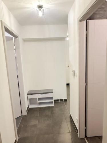 an empty room with a hallway with a white wall at Le jardin secret - Colmar - WIFI in Horbourg