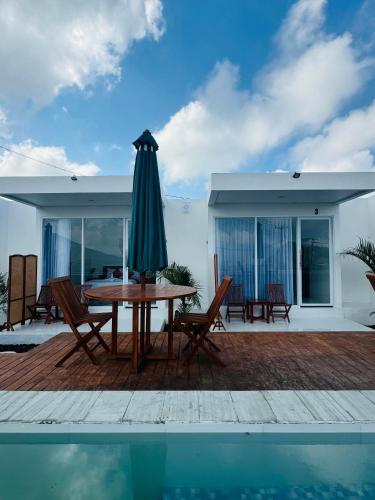 a patio with a table and umbrella next to a pool at Pinggan sky in Gretek