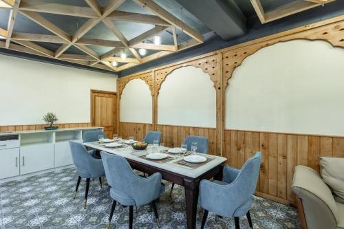 a dining room with a table and chairs at Alaya Stays 3 BHK With Garden - Evaara Woods Breeze in Shimla