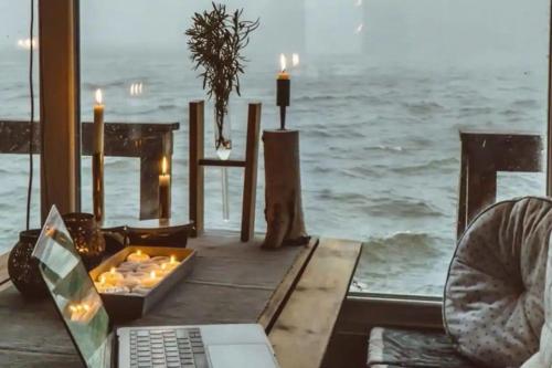 a laptop sitting on a table with a view of the ocean at Archipelago Hideaway - Oasis on the Sea in Värmdö