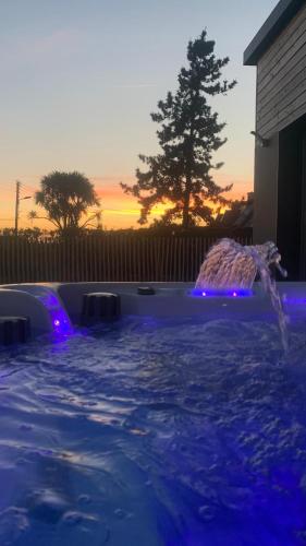 une piscine avec des lumières bleues dans une arrière-cour dans l'établissement Villa Lou Sanaé - Bord de mer - Spa, paddle, Kayak - Classé 4 étoiles, à Santec
