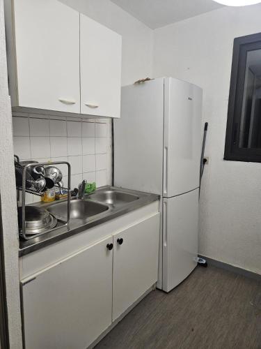 une petite cuisine avec un évier et un réfrigérateur dans l'établissement Chambre proche de la gare de Pessac, à Pessac