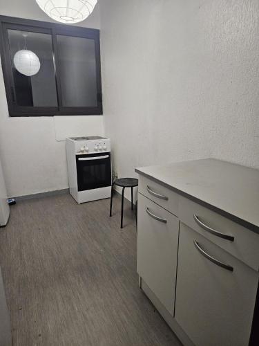 une cuisine avec une cuisinière et un comptoir dans l'établissement Chambre proche de la gare de Pessac, à Pessac