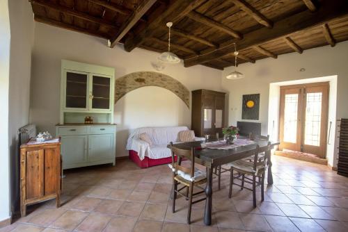 a living room with a table and a kitchen at La Casa di Pan in Bullicame