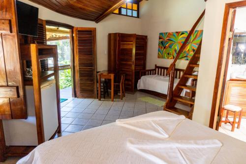 a bedroom with a bed and a room with a kitchen at Pousada Maré Alta in Barra Grande