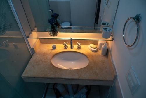 une salle de bain avec un lavabo et un miroir dans l'établissement Paraíso à beira-mar: Beach Living by FTT, à Mangabeira