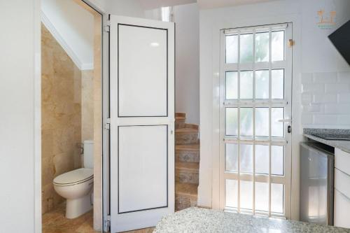 a bathroom with a toilet and a white door at Linda House in Maspalomas